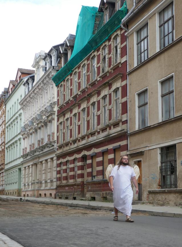 Nico Viereck, der Autor des Bildes, kostümiert sich als Erzengel Michael und läuft in einer Straße in Zeitz.