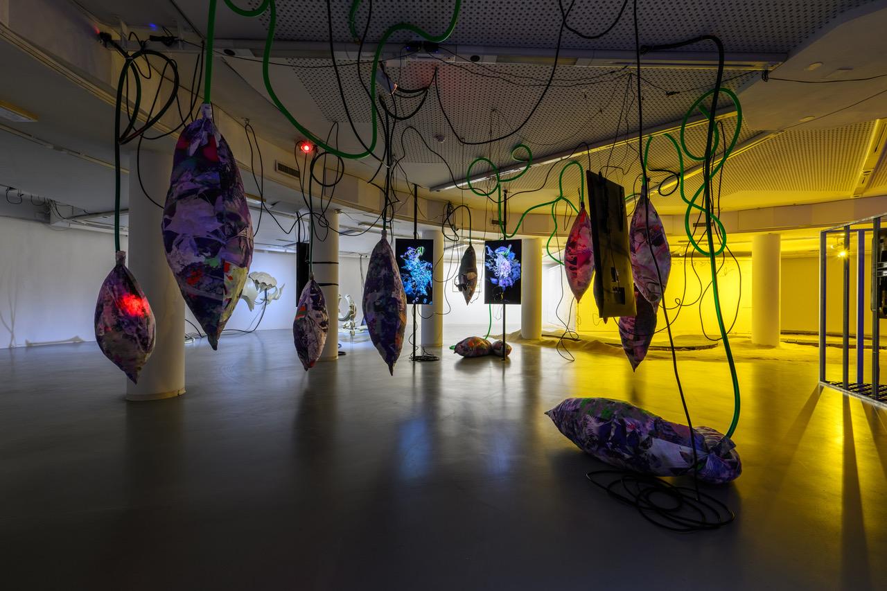 Kunstinstallation im Raum. Objekte hängen von der Decke.